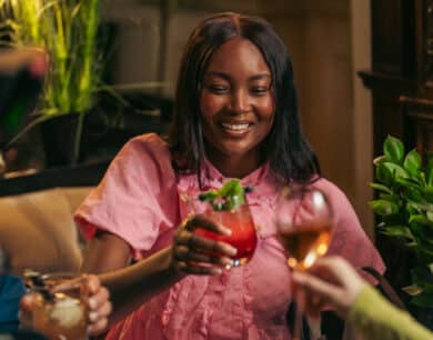 Close up of a guest holding a drink while toasting with others at Monk's Lounge, inside Muckross Park Hotel, KIllarney.