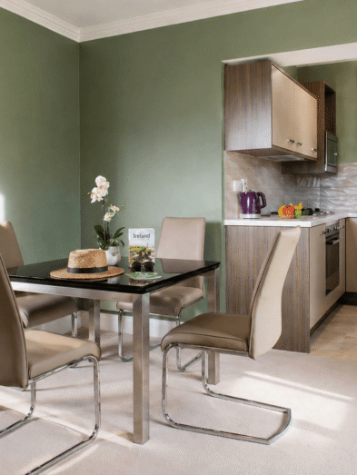 Elegant hotel suite with modern kitchen, dining area, and view of cosy bedroom. Ideal for comfort and relaxation.