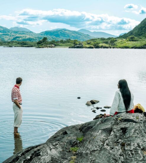 Guests enjoying scenic mountain lake view, perfect for relaxation and nature escapes, with serene waters and lush greenery.