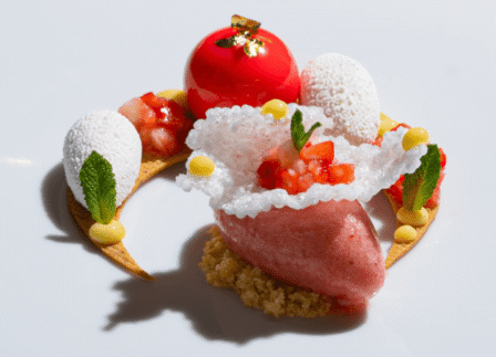 Elegant dessert with fruits and mint, showcasing culinary artistry at luxury hotel restaurant.